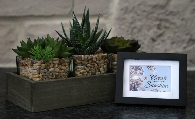 Framed picture with 'Create your own sunshine' quote.
