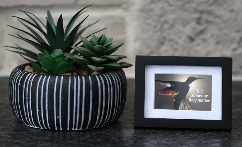 Framed picture with 'Tell someone they matter' quote.