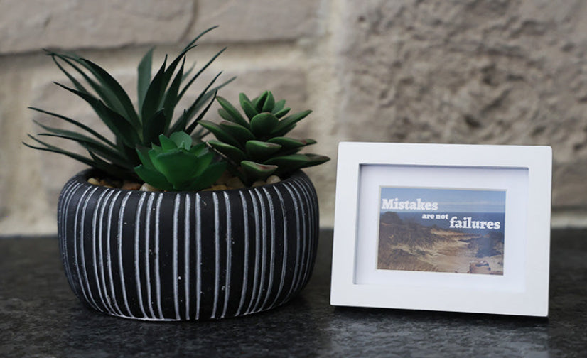 Framed picture with 'Mistakes are not failures' quote.