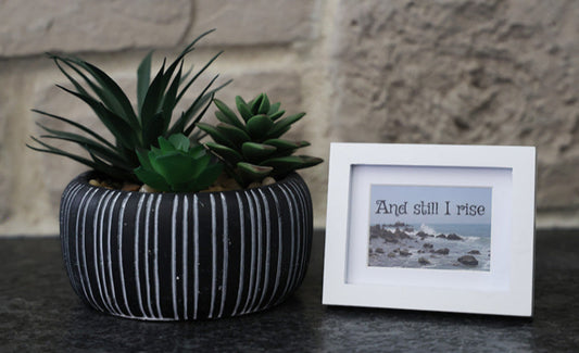 Framed picture with 'And still I rise' quote.
