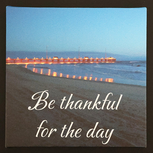 Canvas print with scenic view of beach with a pier with 'Be thankful for the day' text.