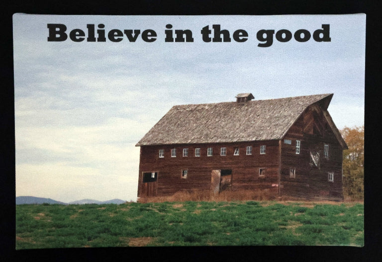 Canvas print with scenic wooden barn in a field with 'Believe in the good' text.