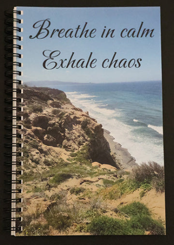 Journal with a scenic cover of a coastal landscape, with text 'Breathe in calm Exhale chaos'.