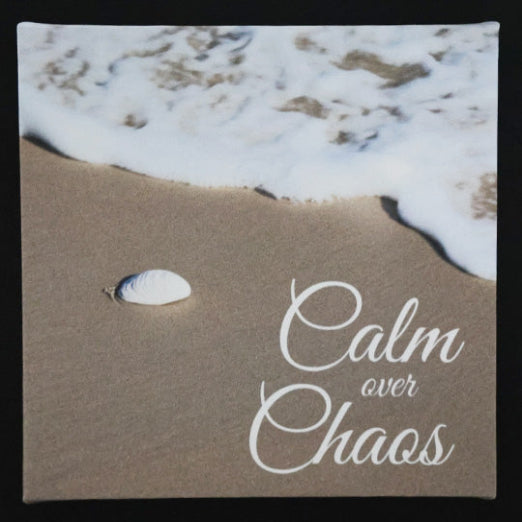 Canvas print with scenic view of a beach and shell, with 'Calm over Chaos' text.
