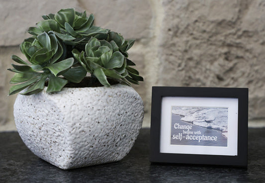 Framed picture with 'Change begins with self-acceptance' quote.