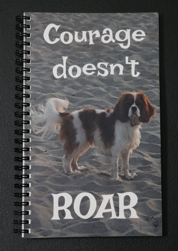 Journal with a dog on the beach on the cover with text 'Courage doesn't roar'.