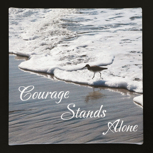 Canvas print with scenic view of bird walking on the beach with 'Courage Stands Alone' text.