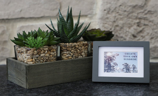 Framed picture with 'Create your own sunshine' quote.