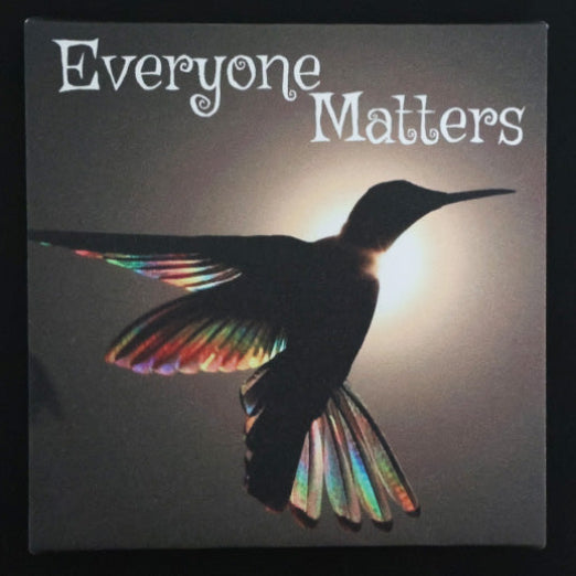 Canvas print with silhouette of a hummingbird with colorful wings against a dark background with 'Everyone Matters' text.