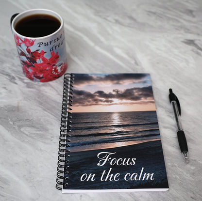 Journal with a beach sunset scene on the comer and 'Focus on the calm' text.