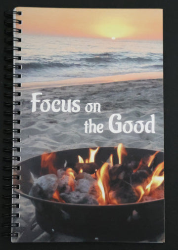 Journal with beach scene and fire pit design, featuring 'Focus on the Good' text.