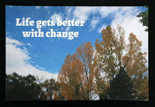 Canvas print with scenic autumn leaves and blue sky with 'Life gets better with change' text.