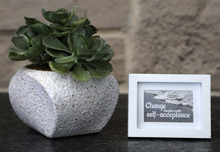 Framed picture with 'Change begins with self-acceptance' quote.