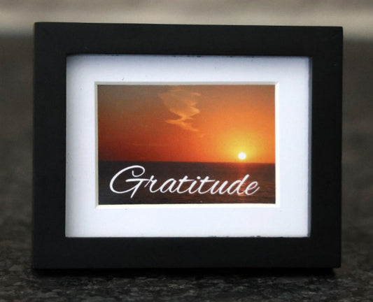 Framed picture with sunset and 'Gratitude' quote.