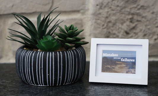 Framed picture with 'Mistakes are not failures' quote.