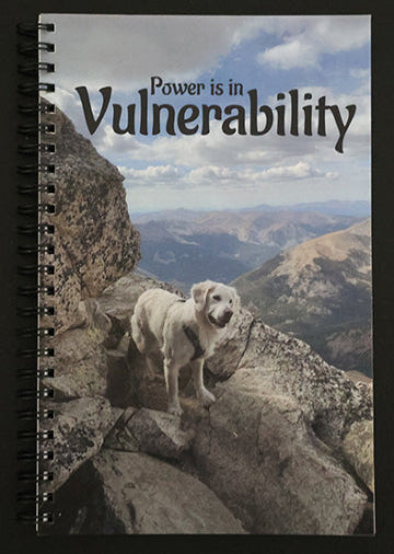Journal with a dog on a mountain peak and 'Power is in Vulnerability' text.