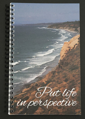 Journal with a scenic cover of a coastal view and 'Put life in perspective' text.