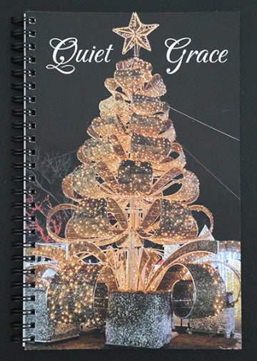 Journal with a decorative Christmas tree design and 'Quiet Grace' text on the cover.