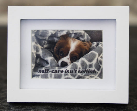 Framed picture with 'Self-care isn't selfish' quote.
