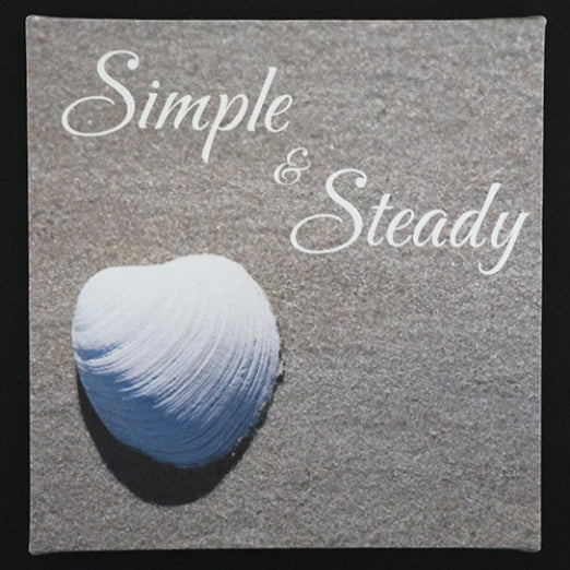 Canvas print with a shell on the beach with 'Simple & Steady' text.