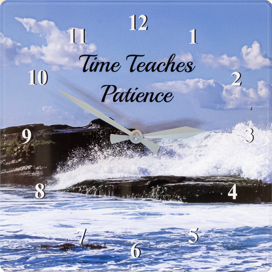 Square wall clock featuring a seascape scene with blue sky, clouds, ocean waves, and dark rocks. White Arabic numeral hour markers are placed over the scene, and the center reads the phrase 'Time Teaches Patience' in black script.