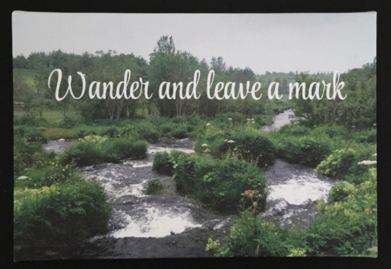 Canvas print with scenic stream flowing through a forest 'Wander and leave a mark' text.