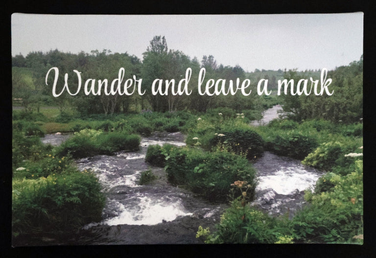 Canvas print with scenic stream flowing through a forest 'Wander and leave a mark' text.
