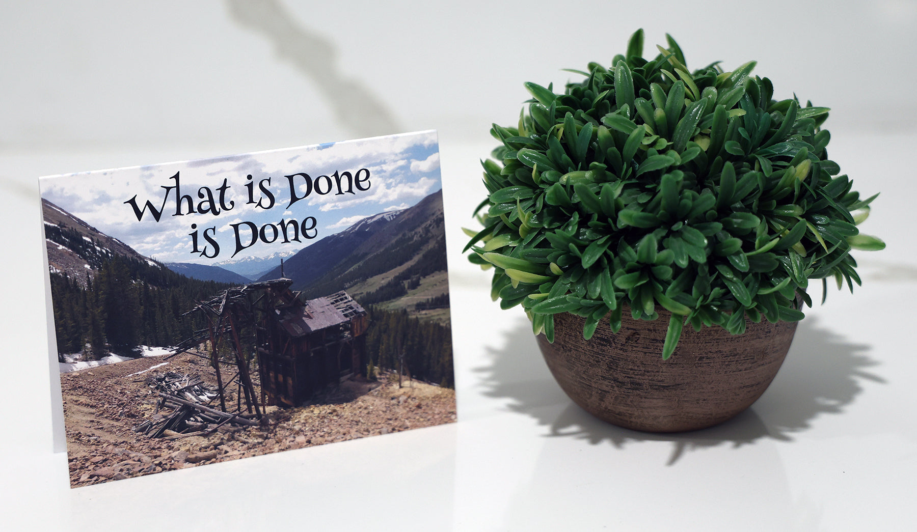 Note card with abandoned mine shack in a mountainous landscape with 'What's done is done' quote.